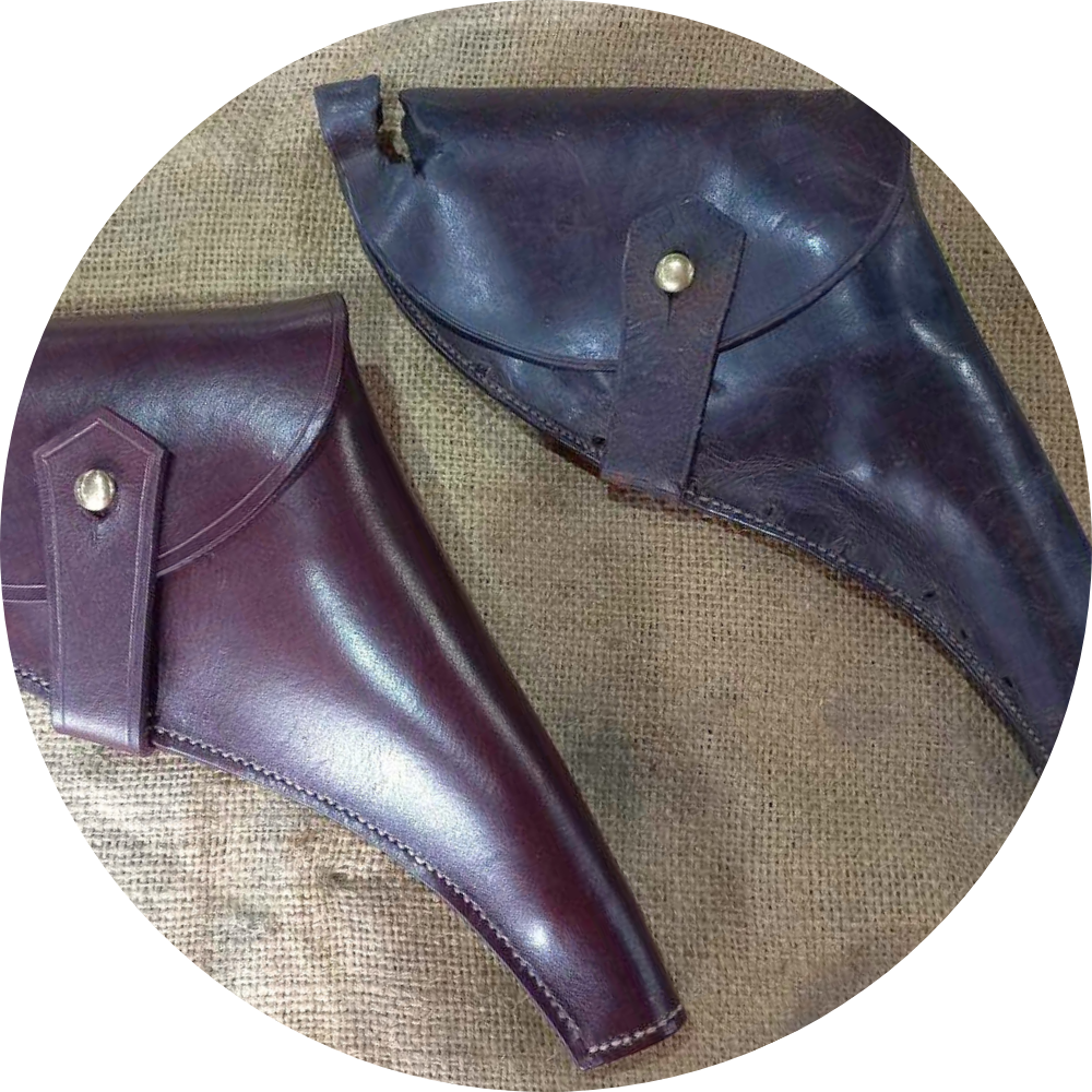 An old holder made from a faded dark brown leather with a rip in the top, placed next to a replica hand-made with a polished red brown leather.