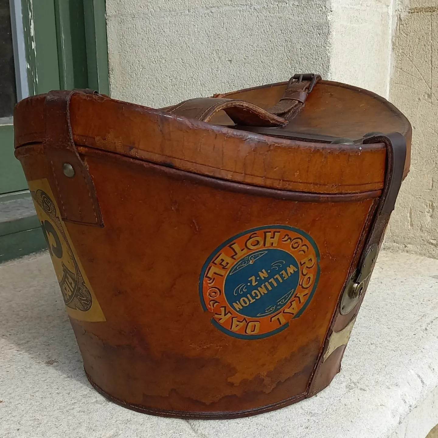 Restored vintage leather case with brass hardware, with old stickers of New Zealand cities.