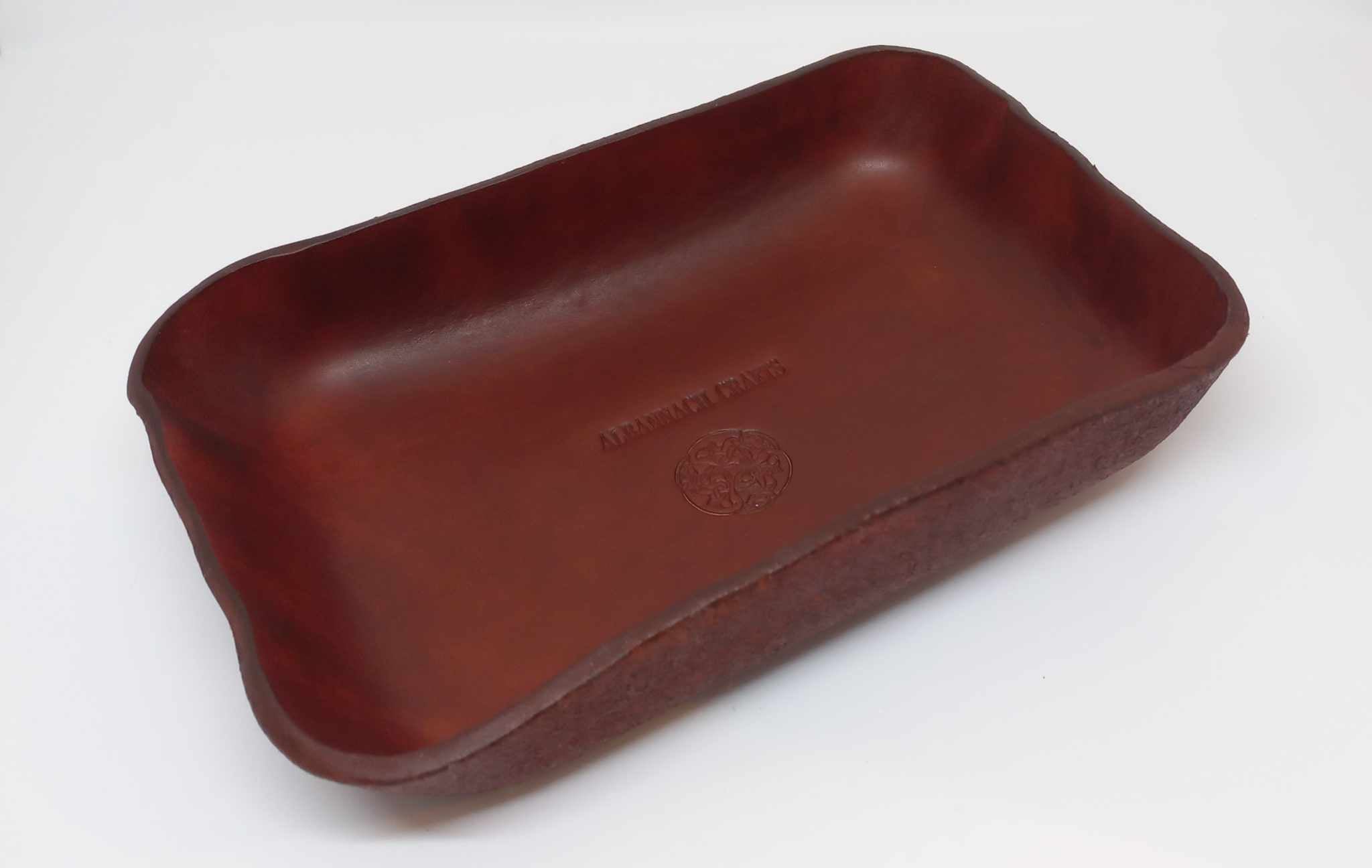 A tray hand-made and moulded with a red brown leather, and stamped with the Albannach Crafts logo.