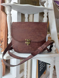 The All Day Bag with shoulder strap, hand-crafted with chocolate brown leather and brass hardware. Stamped with the Albannach Crafts logo.