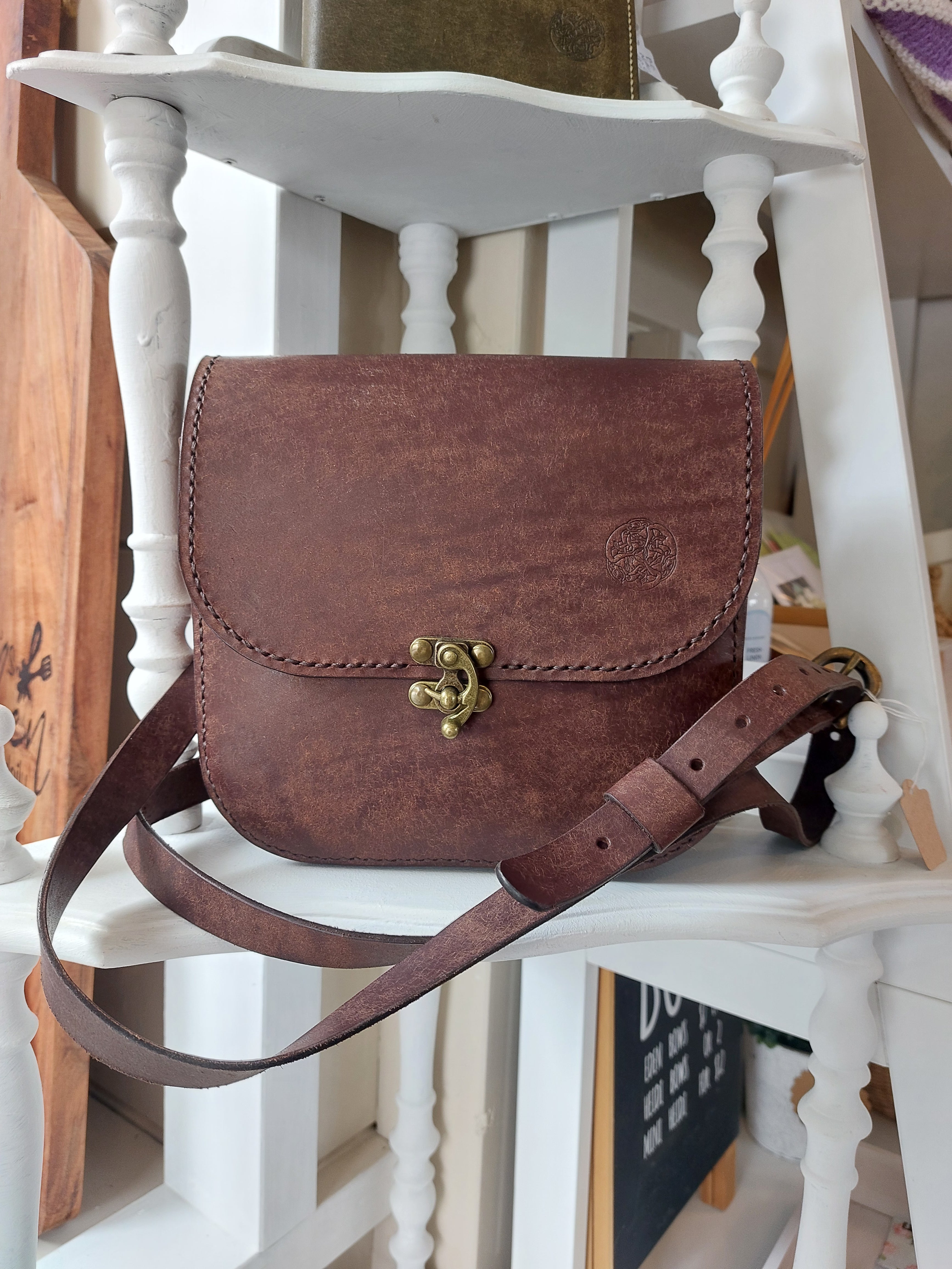 The All Day Bag with shoulder strap, hand-crafted with chocolate brown leather and brass hardware. Stamped with the Albannach Crafts logo.