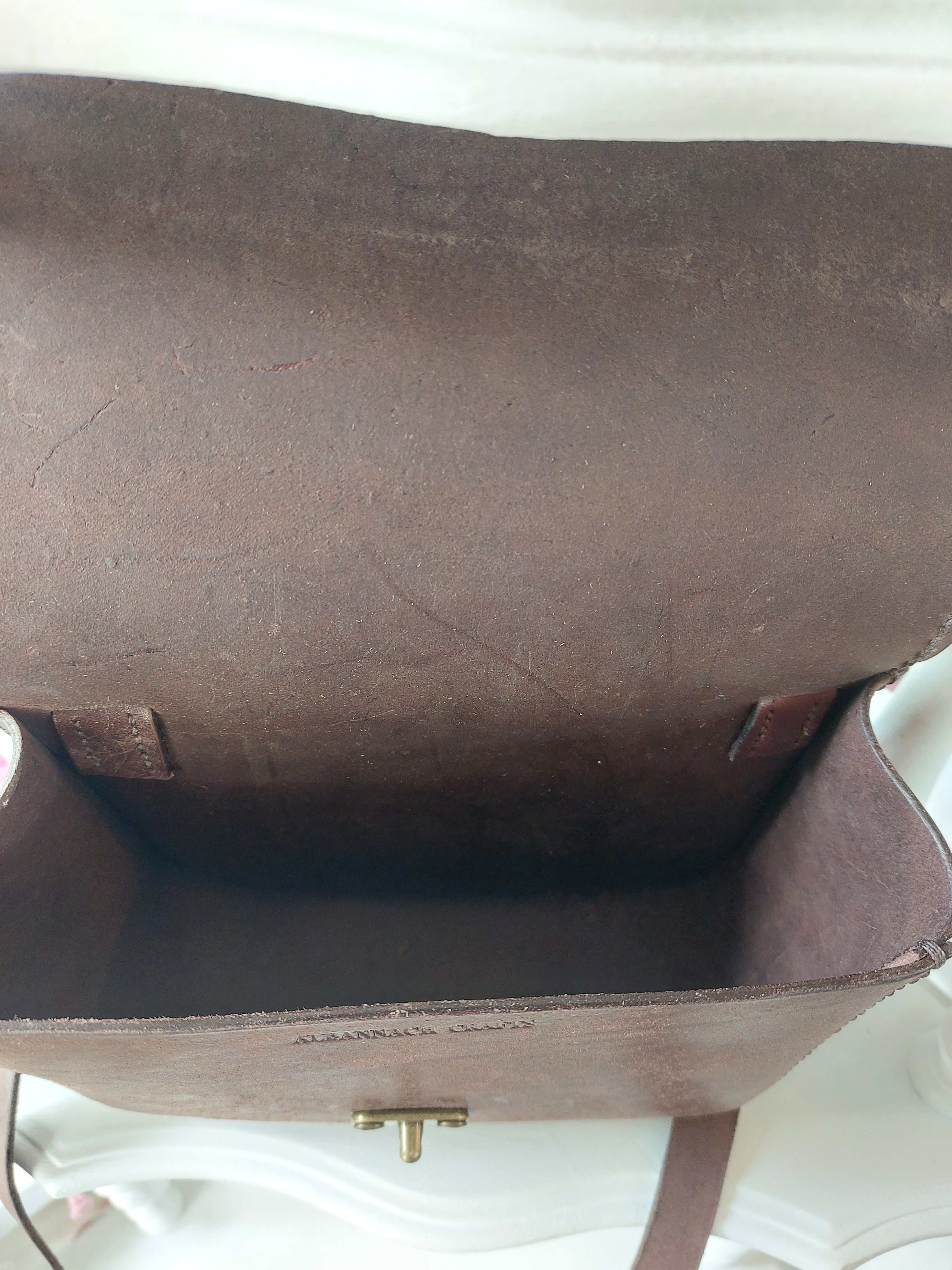 Internal view of The All Day Bag with shoulder strap, hand-crafted with chocolate brown leather and brass hardware. Stamped with the Albannach Crafts logo.
