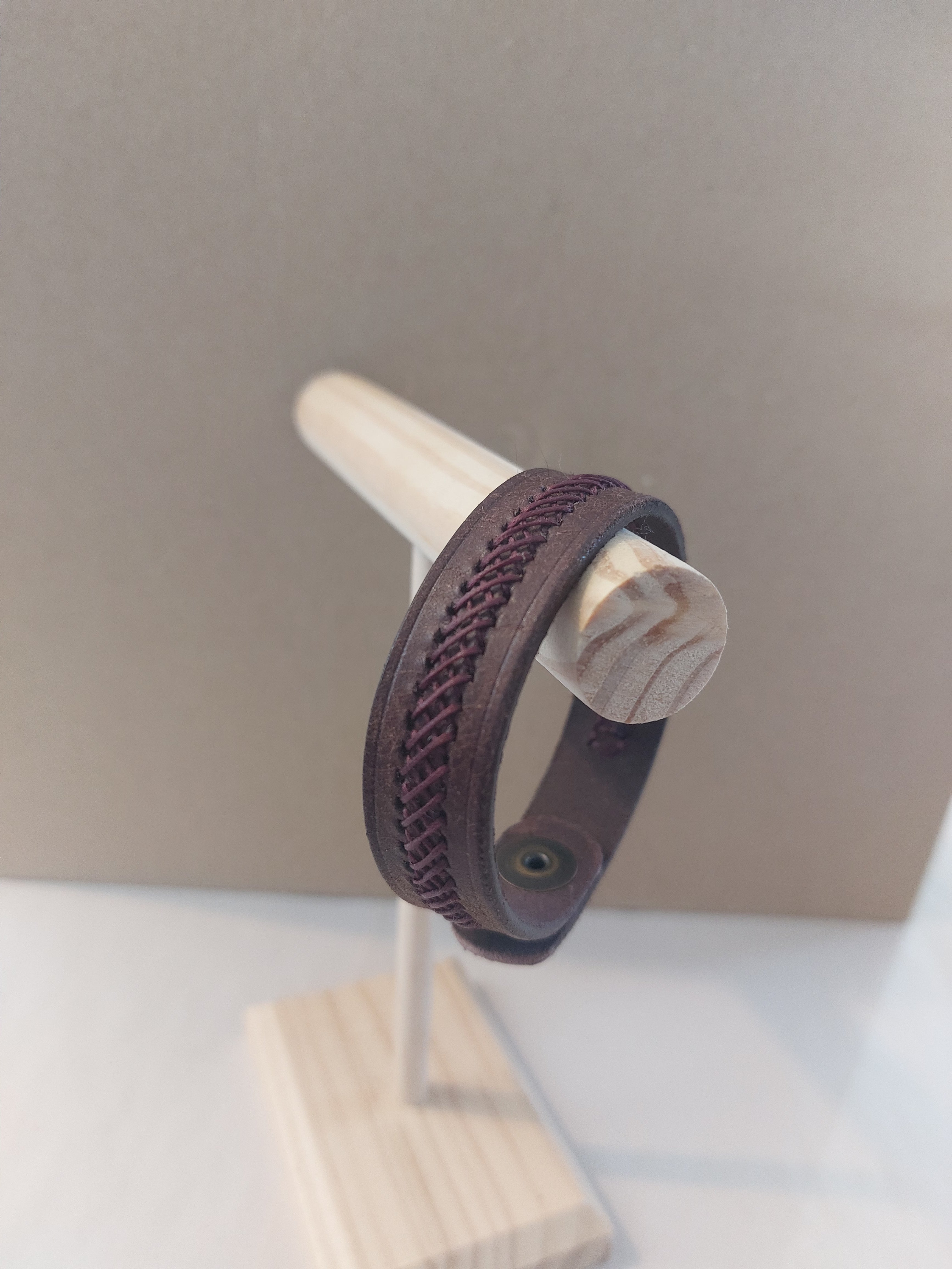 Weave Braid Bracelet made with dark brown leather and beetroot purple stitching.