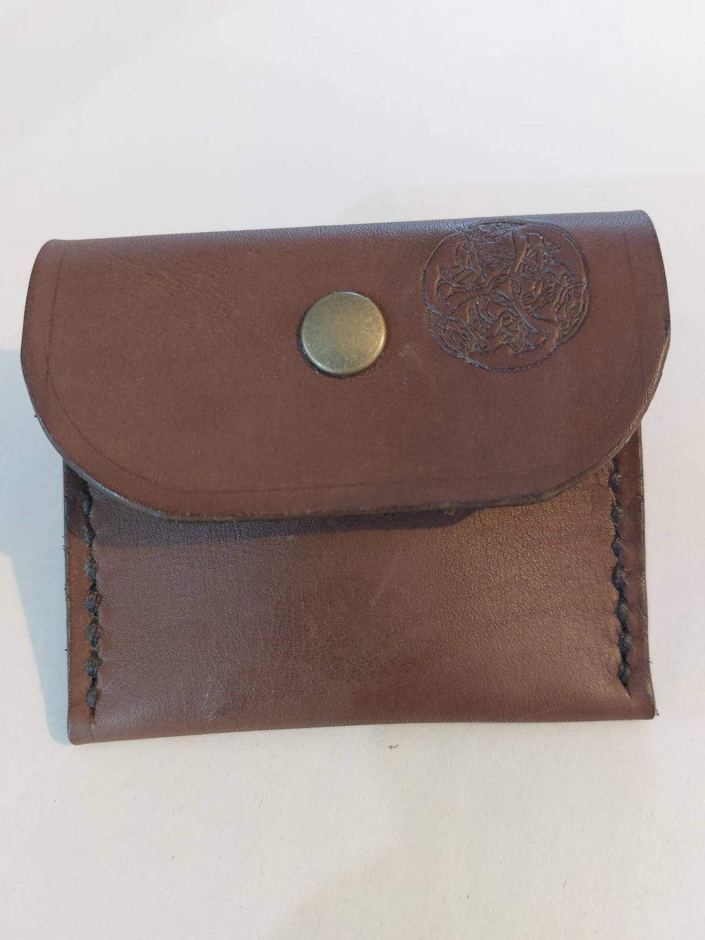 Simple Coin Purse made with brown vegetable-tanned leather and finished with a brass closure. Stamped with the Albannach Crafts logo.