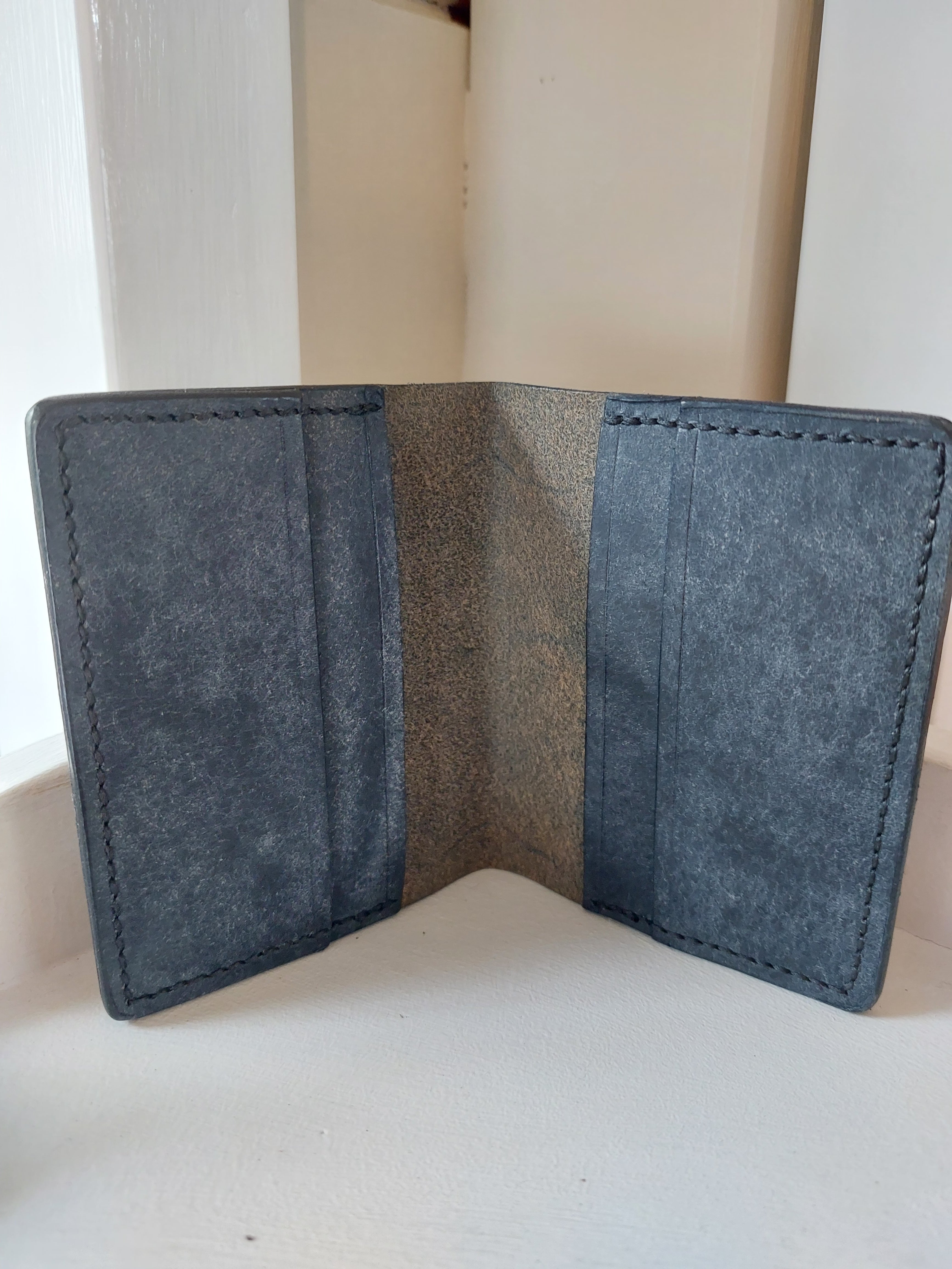 Inside look at the Card Case made from Navy Blue dyed vegetable-tanned leather, and stamped with the Albannach Crafts logo.