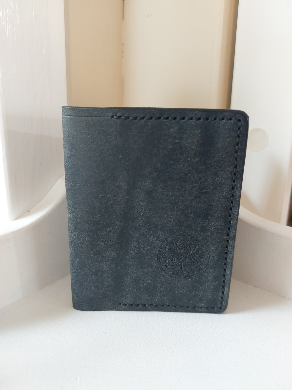 Card Case made from Navy Blue dyed vegetable-tanned leather, and stamped with the Albannach Crafts logo.