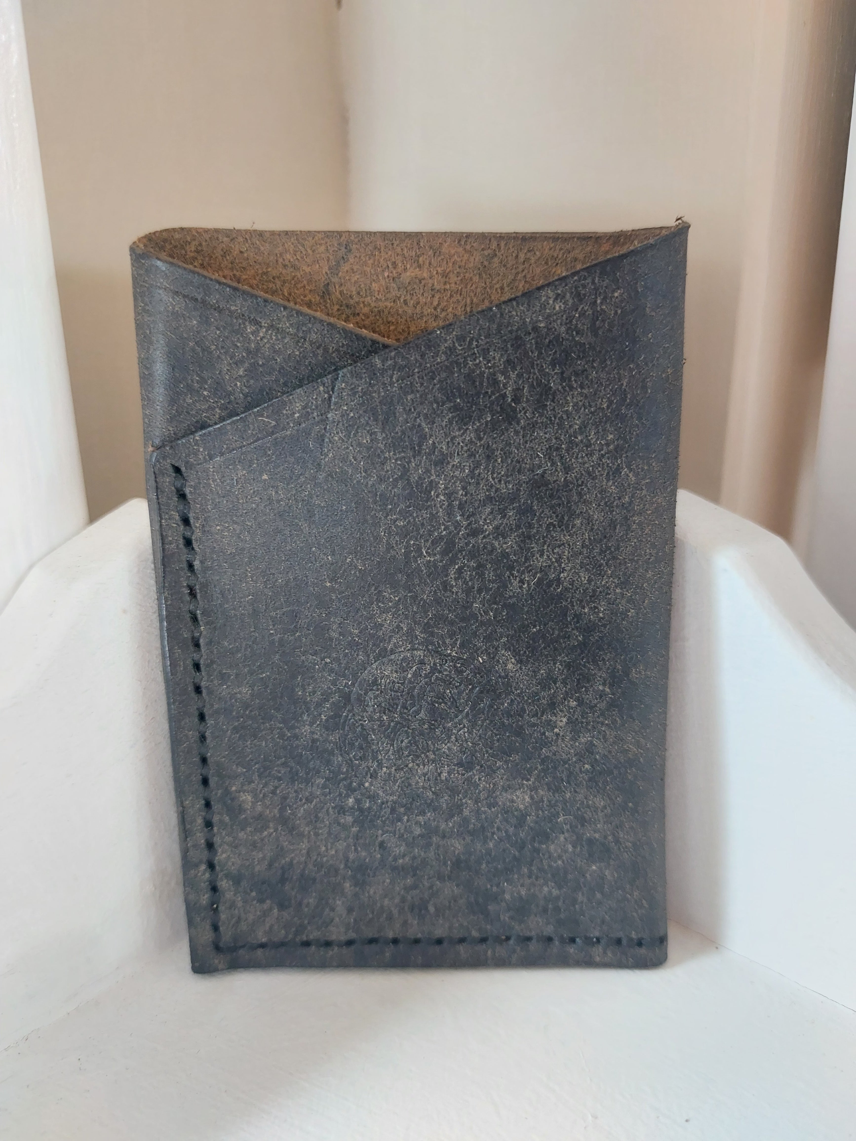 Minimalist Card Case made from Navy Blue dyed vegetable-tanned leather, and stamped with the Albannach Crafts logo.