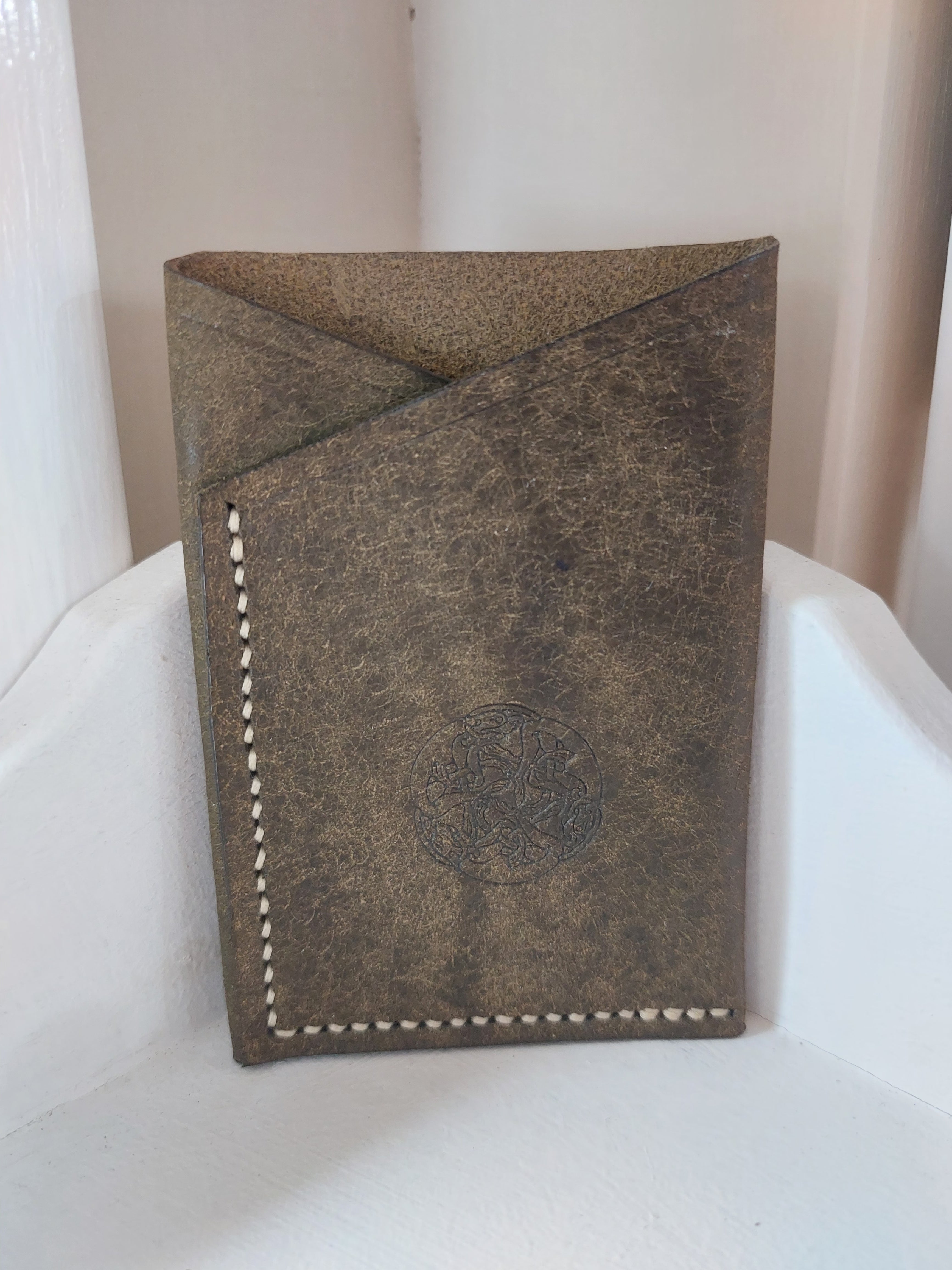 Minimalist Card Case made from Olive Green dyed vegetable-tanned leather, and stamped with the Albannach Crafts logo.