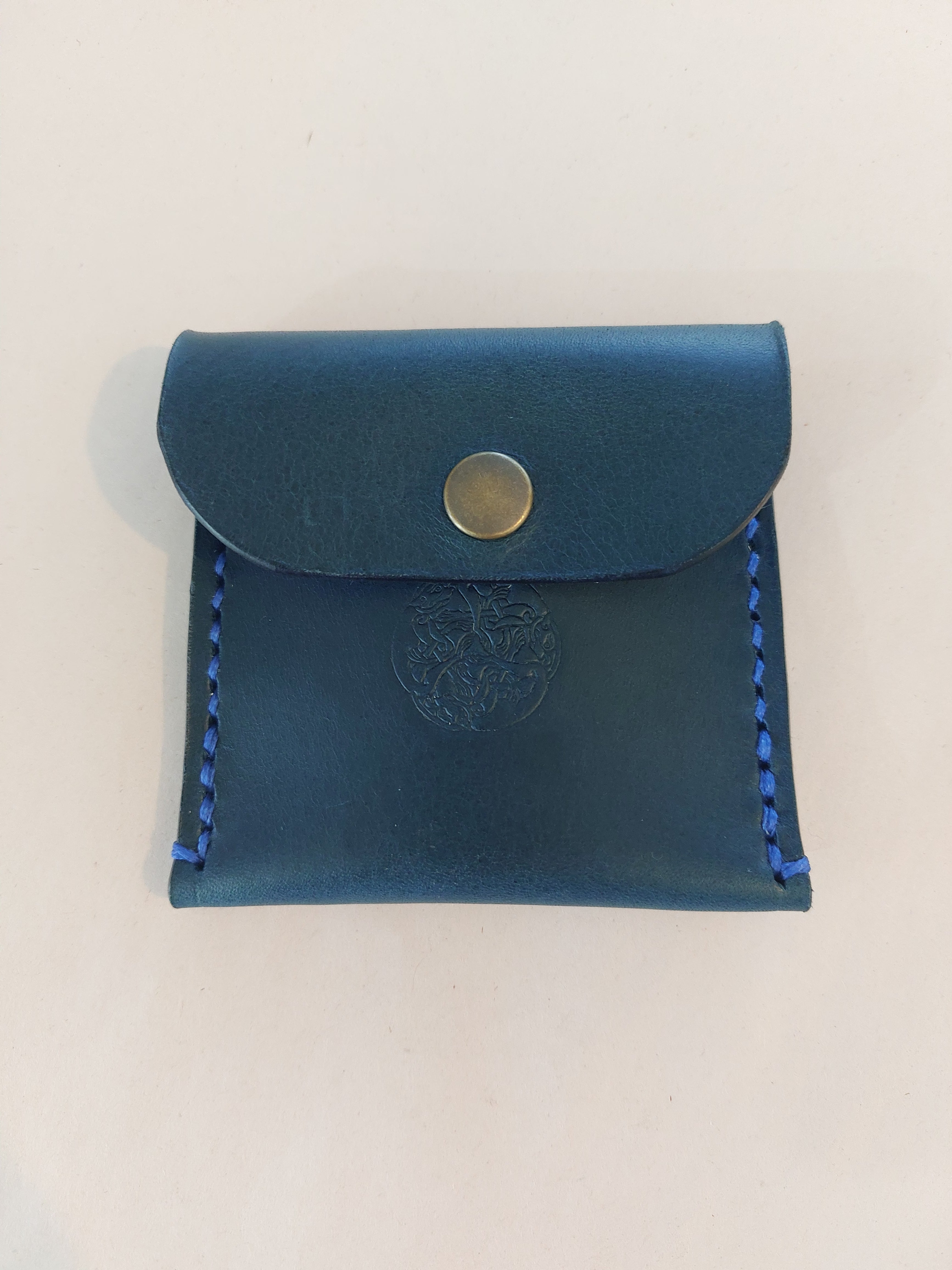 Simple Coin Purse made with navy blue dyed vegetable-tanned leather and finished with a brass closure. Stamped with the Albannach Crafts logo.