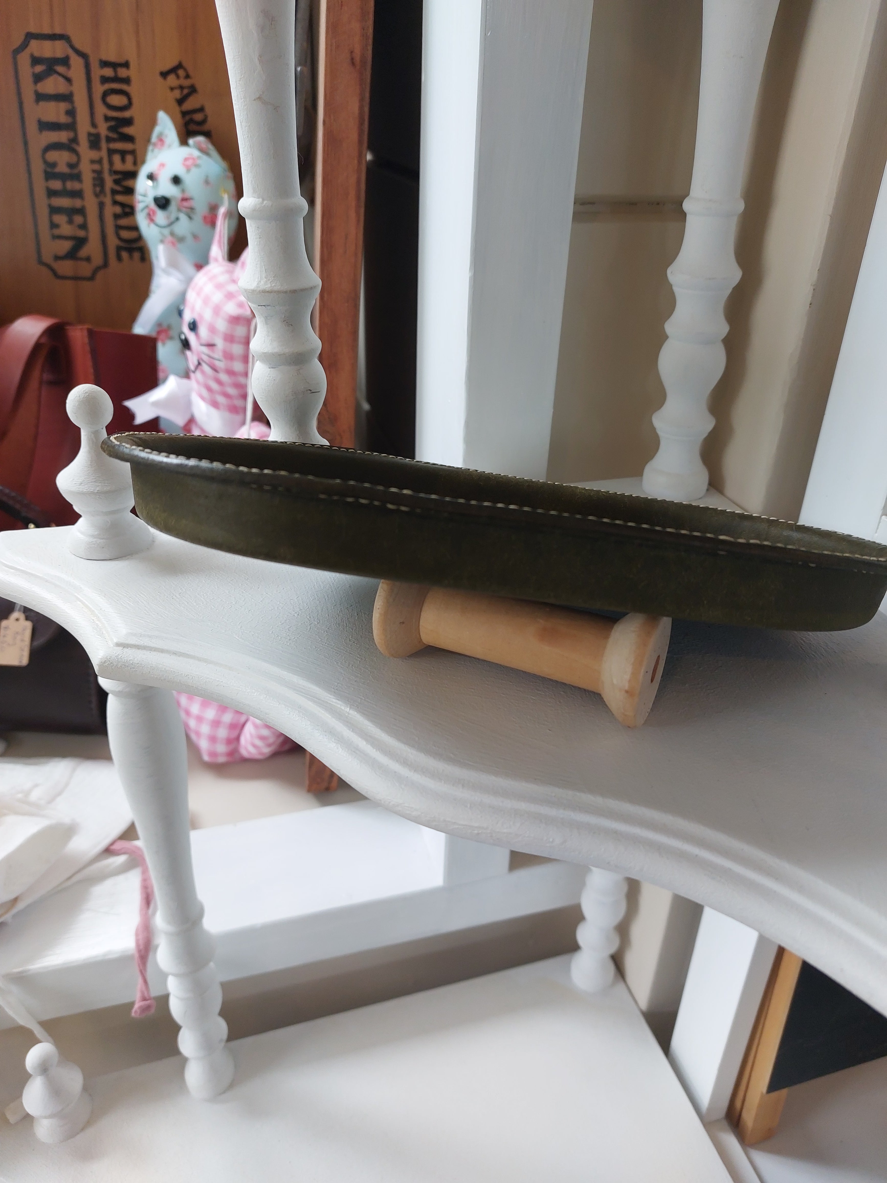 Side angle of the Oval Catch-All Tray handmade with Olive Green dyed leather, created using the wet-forming technique. Stamped with the Albannach Crafts logo.