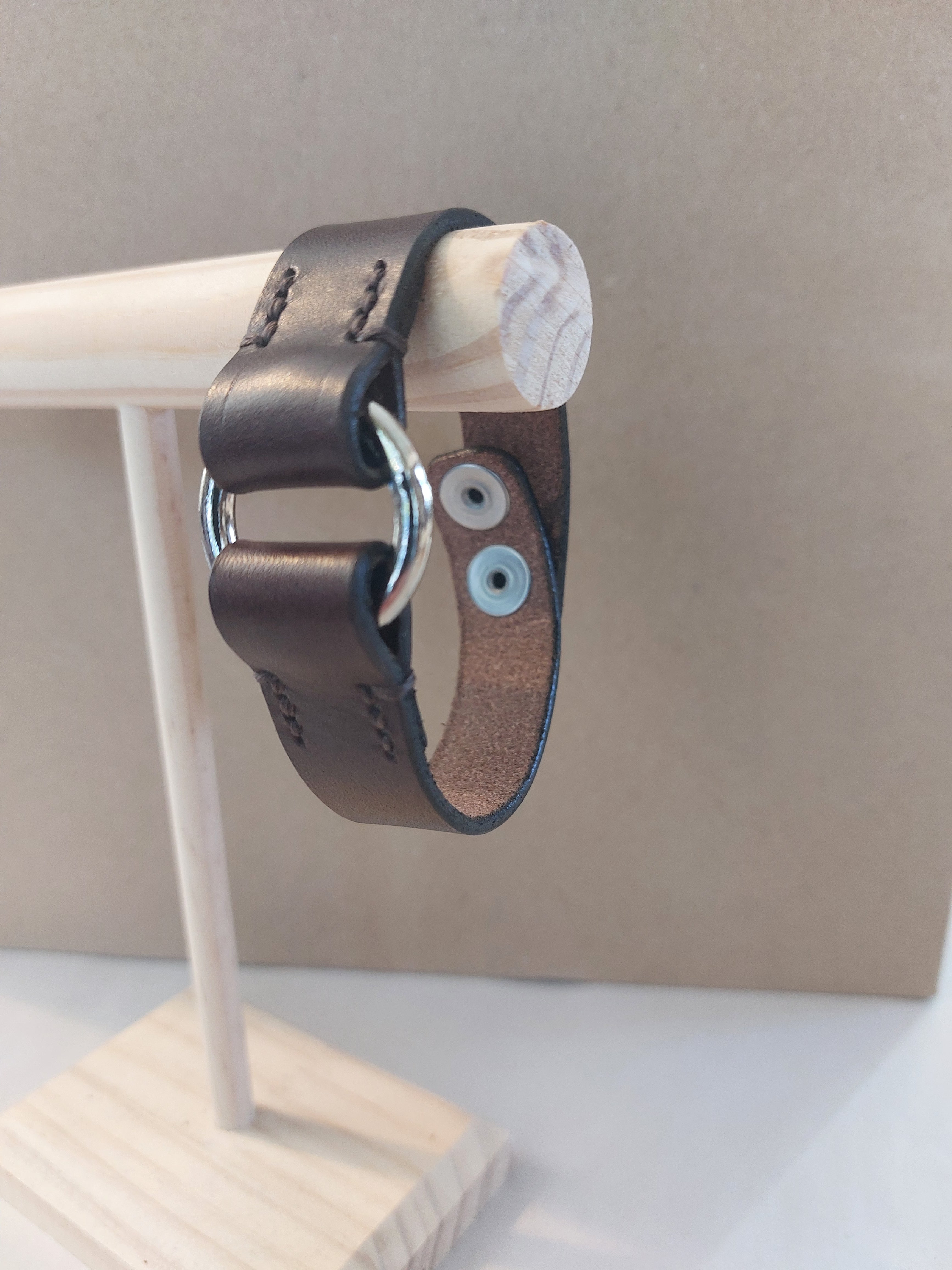 Silver Circle Bracelet made with dark brown leather.