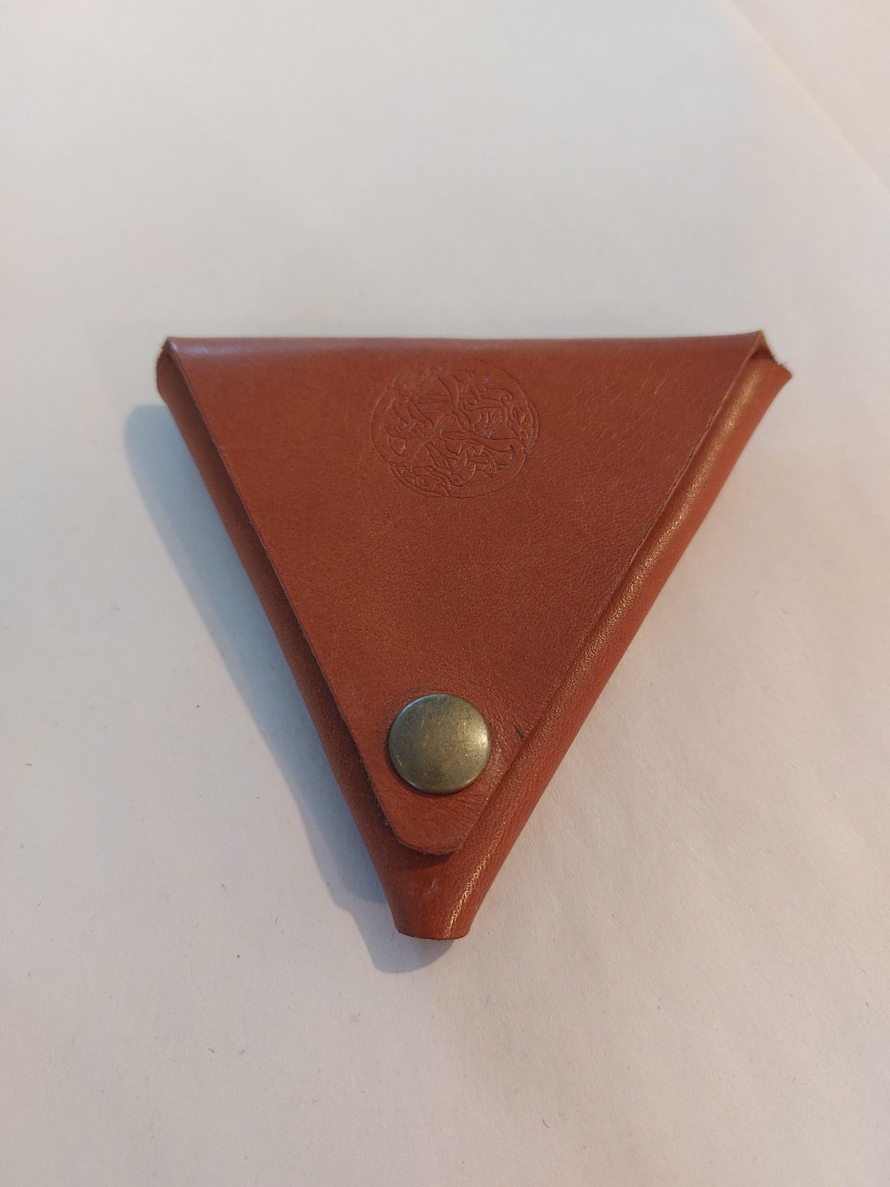 Triangle Coin Purse made with light brown vegetable-tanned leather, with a brass closure.