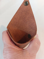 Inside of the Triangle Coin Purse made with light brown vegetable-tanned leather, with a brass closure.